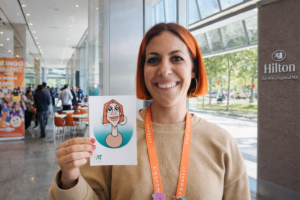 Invitada posando con caricatura digital impresa durante evento en Hilton Diagonal Mar Barcelona.